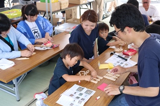 ものづくり体験コーナーで組子コースター制作体験をする親子