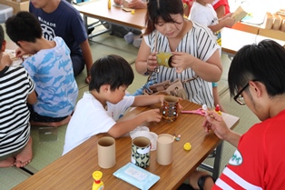 ものづくり体験コーナーでい草のペン立て作りをする親子