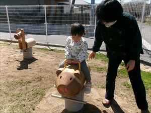 木製ブタさん遊具で遊ぶ子供の写真