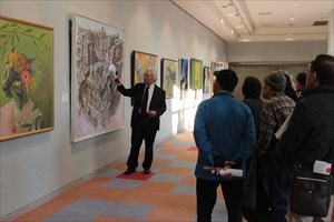 絵画を説明する男性と来場者の写真